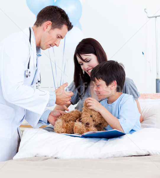 Attractive doctor playing with a little boy and his mother Stock photo © wavebreak_media