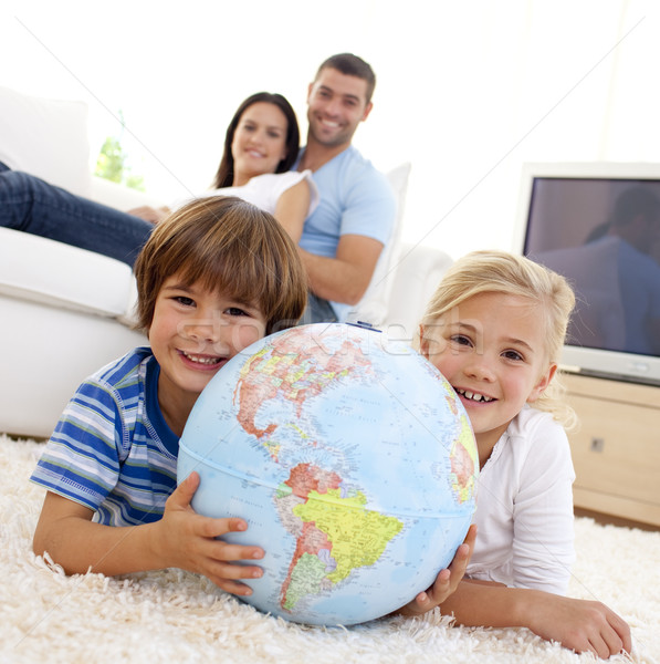 Children playing with a terrestrial globe at home with their parents on sofa Stock photo © wavebreak_media