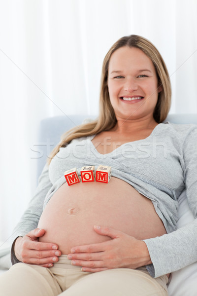 Adorable woman with mom letters on the belly while relaxing on a bed  Stock photo © wavebreak_media