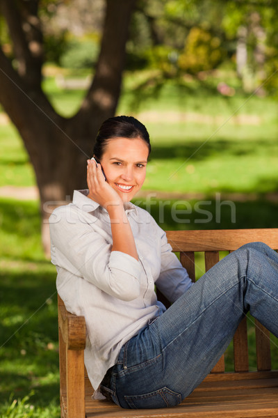 молодые красивая женщина скамейке стороны улыбка лице Сток-фото © wavebreak_media