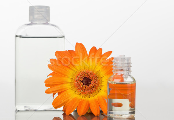 A glass phial and an orange gerbera with a glass flask against white background Stock photo © wavebreak_media
