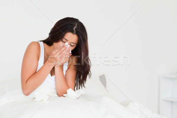 goodlooking woman having a cold sitting in bed in bedroom Stock photo © wavebreak_media