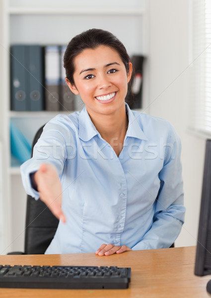 Beautiful woman inviting somebody to seat while looking at the camera at the office Stock photo © wavebreak_media