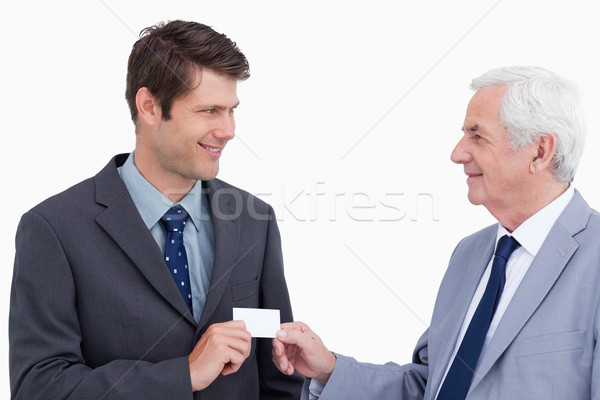 Close up of businessmen exchanging business card against a white background Stock photo © wavebreak_media