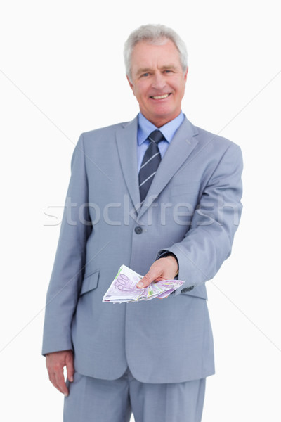 Smiling mature tradesman holding bank notes in his hand against a white background Stock photo © wavebreak_media