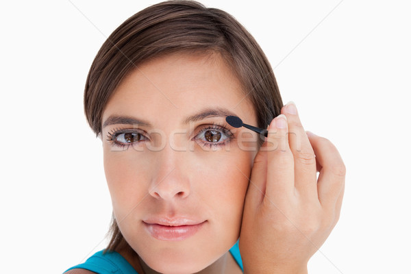 Young woman looking far ahead while putting eyeshadow on her eyelid Stock photo © wavebreak_media