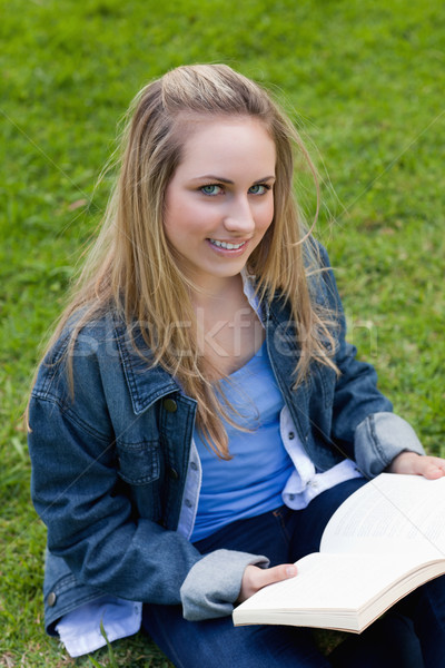 Jeune femme regarder caméra livre séance [[stock_photo]] © wavebreak_media