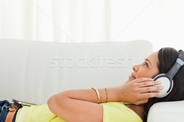 Young Latino listening music with a smartphone while lying on a sofa Stock photo © wavebreak_media