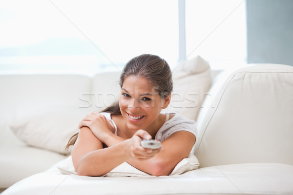 Mujer sofá senalando remoto salón ventana Foto stock © wavebreak_media
