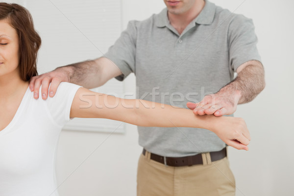 Woman sitting while a doctor is examining her arm in a room Stock photo © wavebreak_media