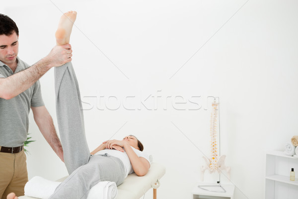 Physiotherapist raising the leg of a woman in a room Stock photo © wavebreak_media