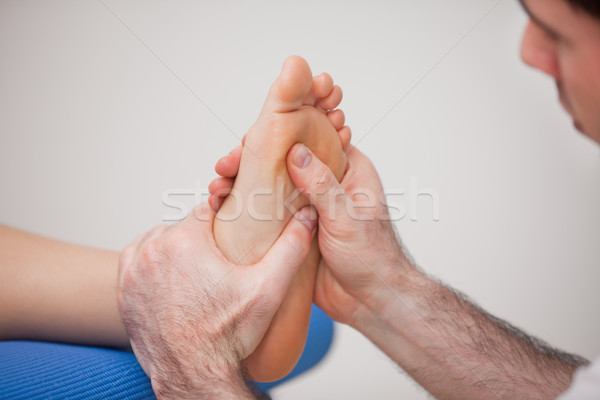 Podiatrist practicing reflexology on the foot of woman in a room Stock photo © wavebreak_media