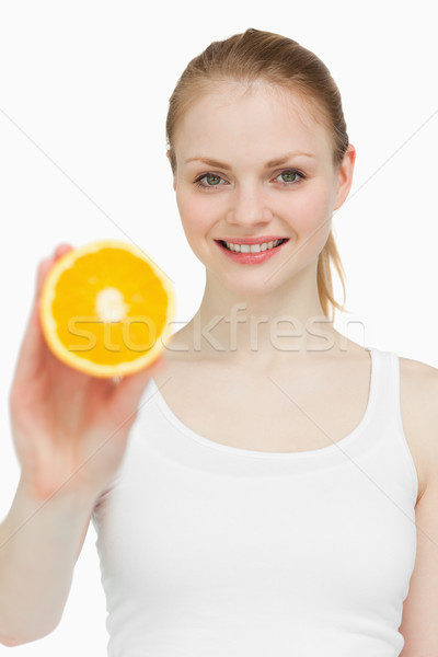 Woman holding an orange while smiling Stock photo © wavebreak_media