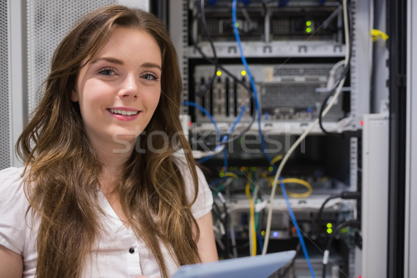 Femeie zambitoare în picioare servere stocare a datelor muncă reţea Imagine de stoc © wavebreak_media