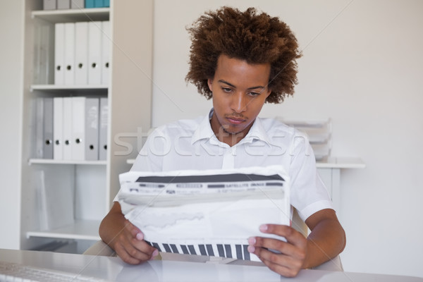 Casual focused businessman reading newspaper at desk Stock photo © wavebreak_media