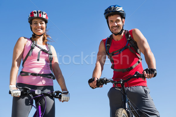 Fit cyclist couple standing at the summit smiling at camera Stock photo © wavebreak_media