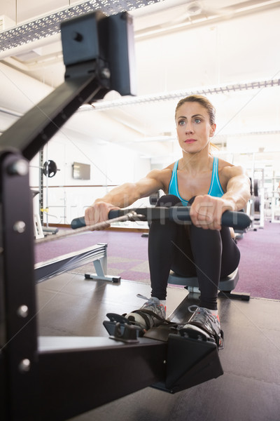 Young woman working on fitness machine at gym Stock photo © wavebreak_media