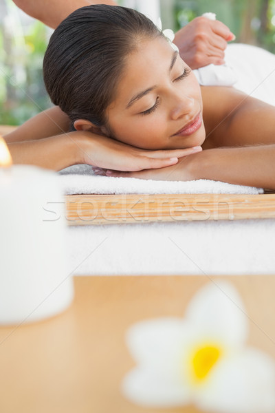 Beautiful brunette enjoying a herbal compress massage Stock photo © wavebreak_media