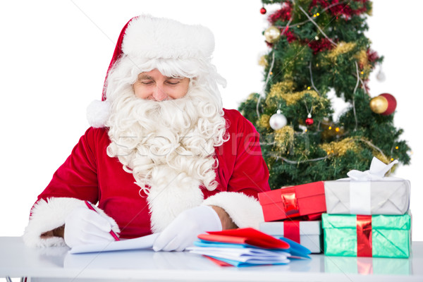 Happy santa writing letter for gifts Stock photo © wavebreak_media