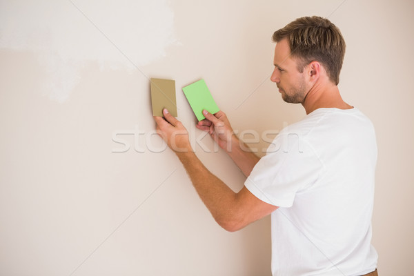 Handsome decorator sanding down the wall  Stock photo © wavebreak_media