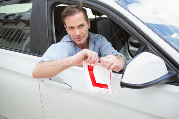 Smiling male driver tearing up his L sign Stock photo © wavebreak_media