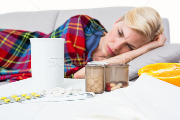 Sick blonde woman lying on the couch Stock photo © wavebreak_media