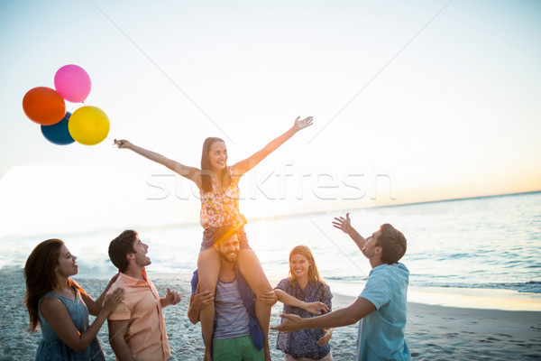 Happy friends dancing on the sand with balloon Stock photo © wavebreak_media