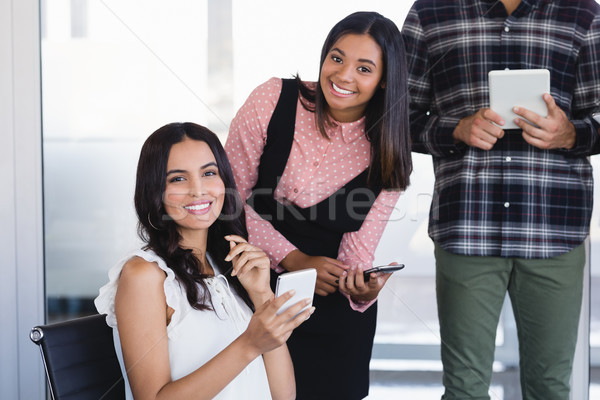 Retrato sonriendo negocios colegas teléfonos móviles creativa Foto stock © wavebreak_media