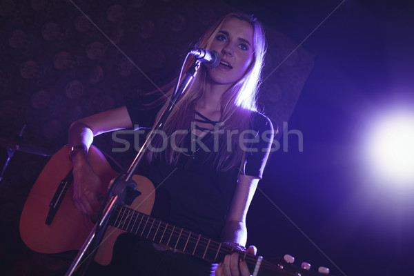 Femeie cântăreaţă chitară club de noapte Imagine de stoc © wavebreak_media
