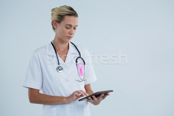 Female doctor with Breast Cancer Awareness ribbon using tablet computer Stock photo © wavebreak_media