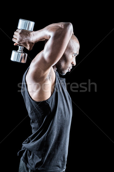 Side view of muscular man exercising with dumbbell Stock photo © wavebreak_media