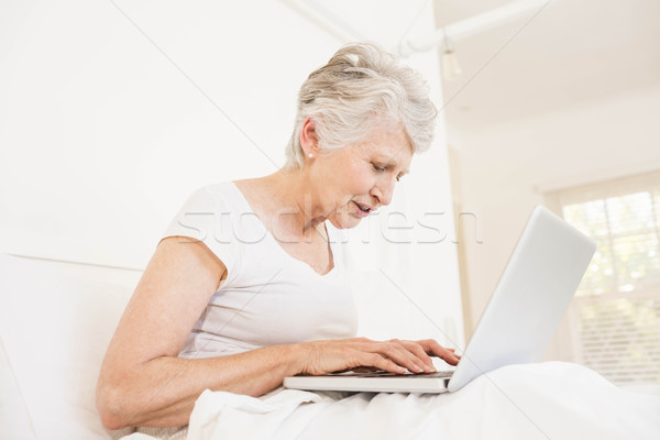 Reife Frau mit Laptop Sitzung Bett Computer Frau Stock foto © wavebreak_media