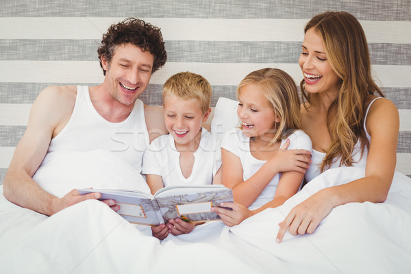 Szczęśliwą rodzinę czytania książki bed relaks domu Zdjęcia stock © wavebreak_media