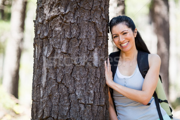 Femeie zambitoare prezinta copac fericit verde mers Imagine de stoc © wavebreak_media