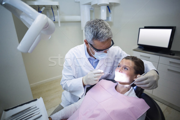 Dentist examining a young patient with tools Stock photo © wavebreak_media
