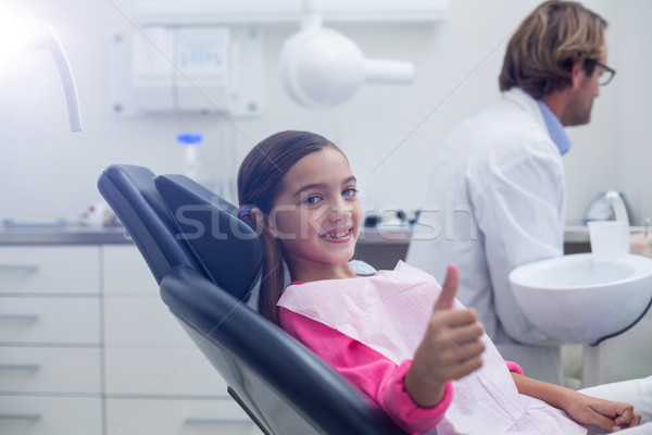 Smiling young patient sitting on dentists chair Stock photo © wavebreak_media