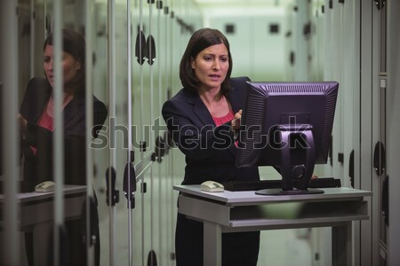 Stock photo: Technician working on personal computer while analyzing server