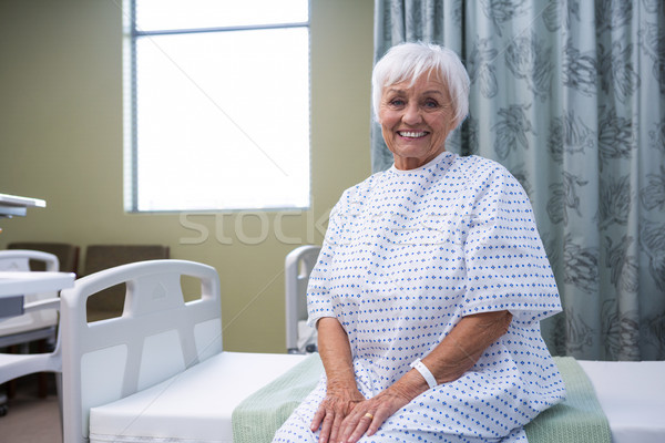 Glimlachend senior patiënt vergadering bed ziekenhuis Stockfoto © wavebreak_media