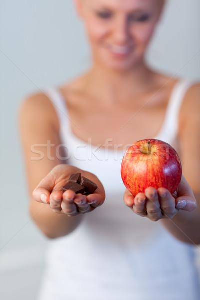 Stock photo: Blonde woman showing chocolate and apple focus on chocolate and apple 