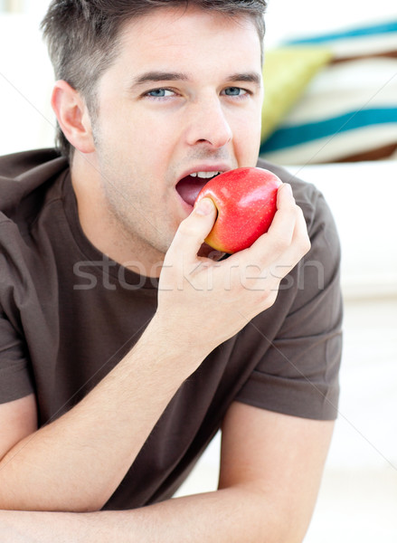 Jeune homme sol manger pomme rouge maison pizza [[stock_photo]] © wavebreak_media