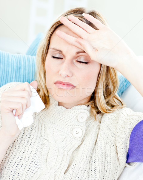Diseased woman with headache lying on the sofa in the living-room at home Stock photo © wavebreak_media