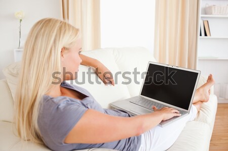 Woman switching on her laptop in her living room Stock photo © wavebreak_media