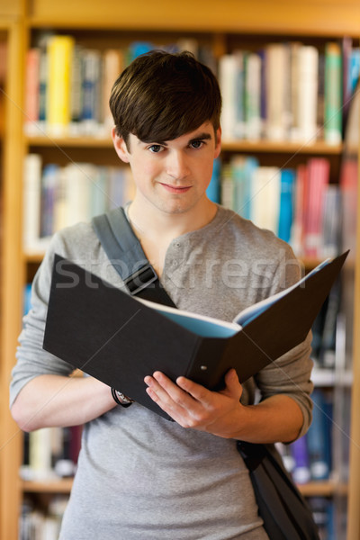 Portrait of a smiling student holding a binder while looking at the camera Stock photo © wavebreak_media