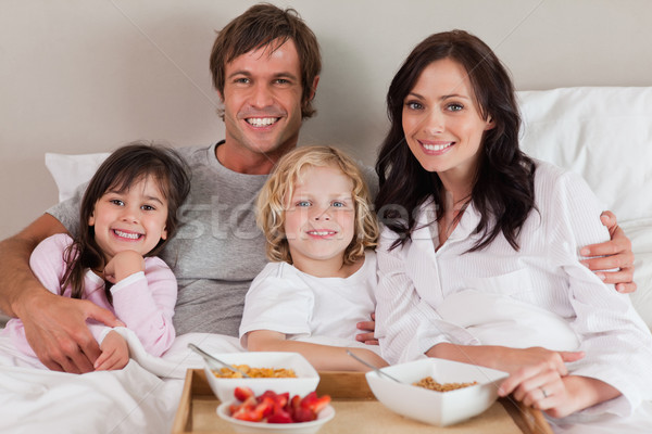 Famille heureuse déjeuner ensemble chambre sourire maison [[stock_photo]] © wavebreak_media