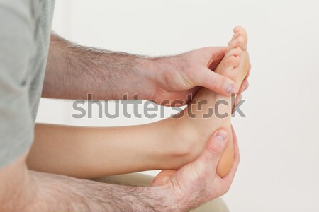 Osteopath holding the ball of a foot in a room Stock photo © wavebreak_media