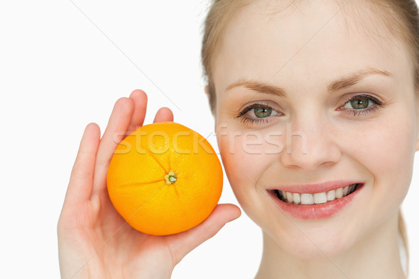 fair-haired woman holding an orange against white background Stock photo © wavebreak_media