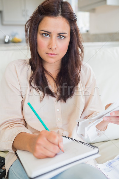 Young woman calculating bills on sofa at home Stock photo © wavebreak_media