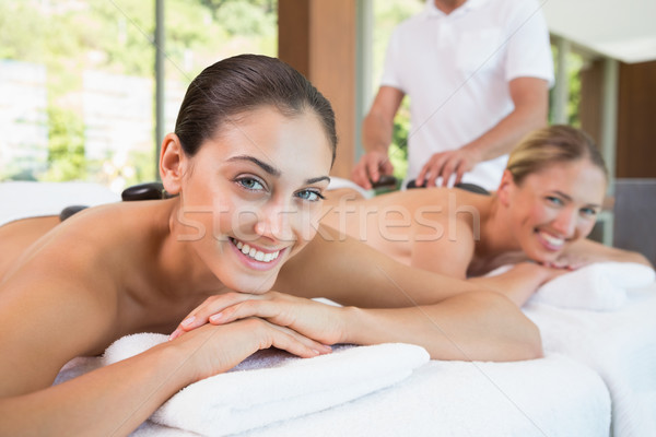 Pretty friends lying on massage tables with hot stones on their  Stock photo © wavebreak_media