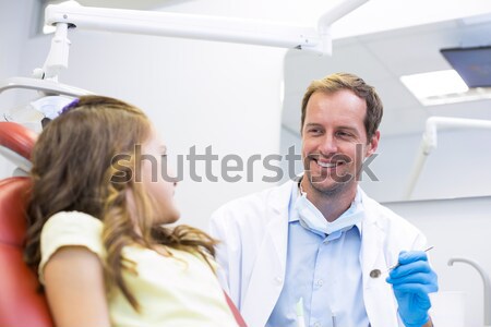 Pediatric dentist smiling with little girl in the chair Stock photo © wavebreak_media