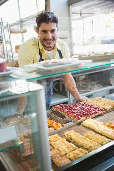 Uśmiechnięty pracownika stwarzające za Licznik piekarni Zdjęcia stock © wavebreak_media